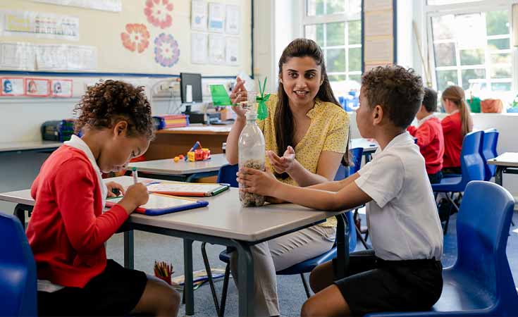 female teacher helping students with a project