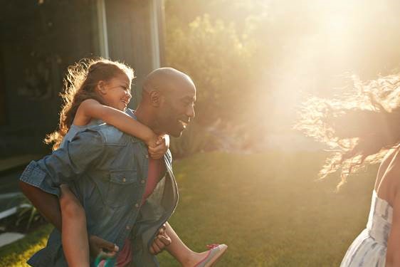 father giving daughter a piggy back ride