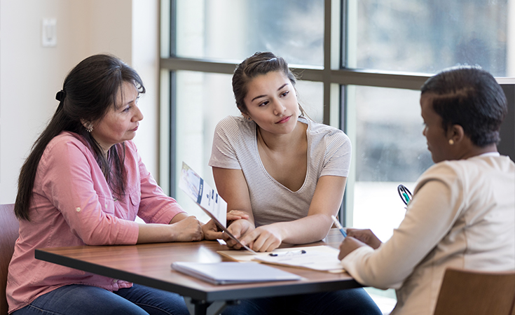 two women sitting and talking with a financial professional