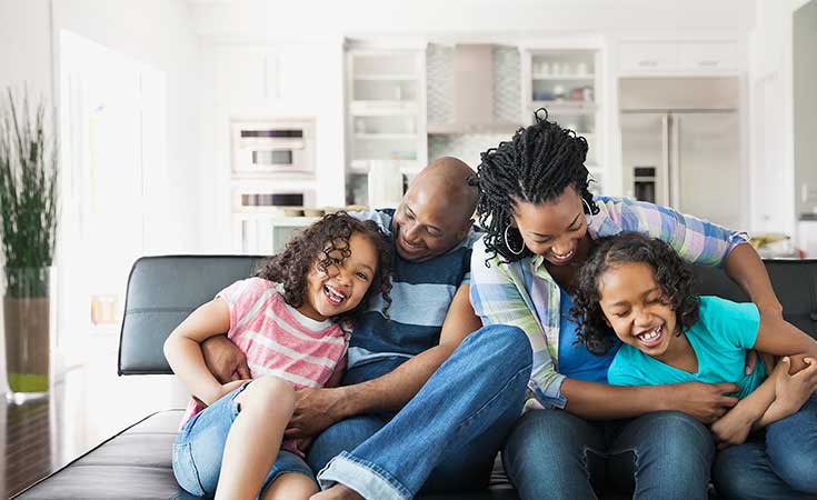 family hugging and laughing together on a couch