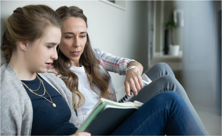 mother and daughter looking at a notebook